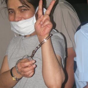 Guler Zere masquée menottée