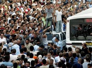 le bus, cerné par les habitants, après le massacre