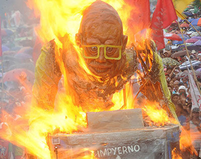 Les manifestants brûlent une effigie du président des Philippines.