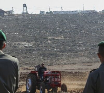 Un paysan palestinien de Qusra travaillant la terre, à l'arrière plan, la colonie sioniste d'Esh Kodesh