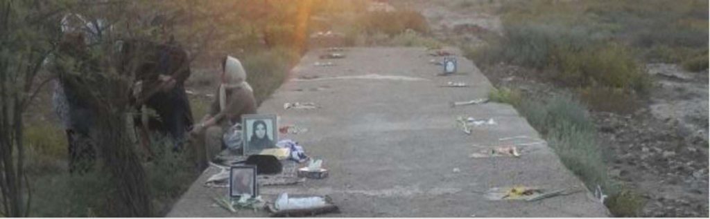 Famille se recueillant sur la fosse commune à Ahvaz