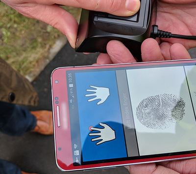 Un scanner d'empreinte portatif relié à un smartphone.