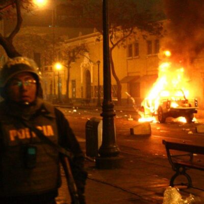 Un véhicule de police en feu hier dans les rue de Lima