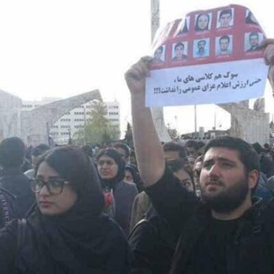 Un manifestant de l'Université Awad brandit les portraits de ses 10 condisciples tués dans l'accident