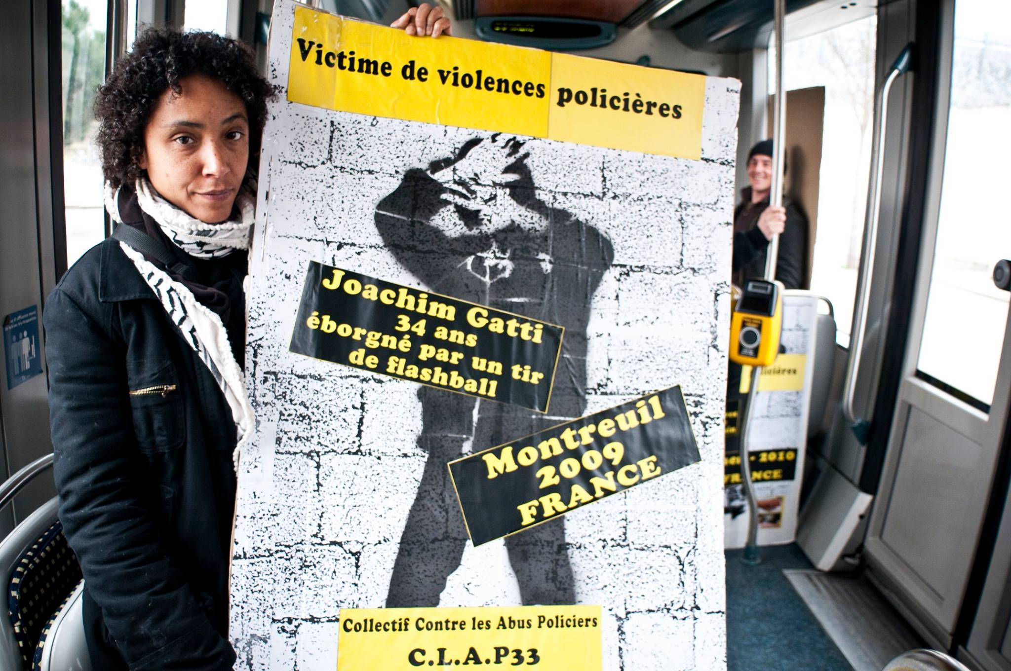 Militante du CLAP portant une pancarte contre les violences policières Militante du CLAP portant une pancarte contre les violences policières
