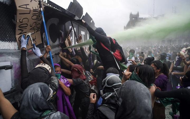 Les manifestantes essayent de pénétrer dans le palais national à Mexico à l'occasion du 8 mars 2021