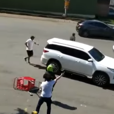 Un milicien ouvrant le feu sur les manifestants à coté d'un policier en uniforme