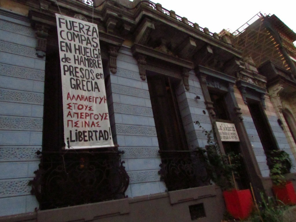 Une banderole posée sur un immeuble occupé à Montevideo : “Solidarité avec les compagnon-ne-s en grève de la faim en Grèce, Liberté !“
